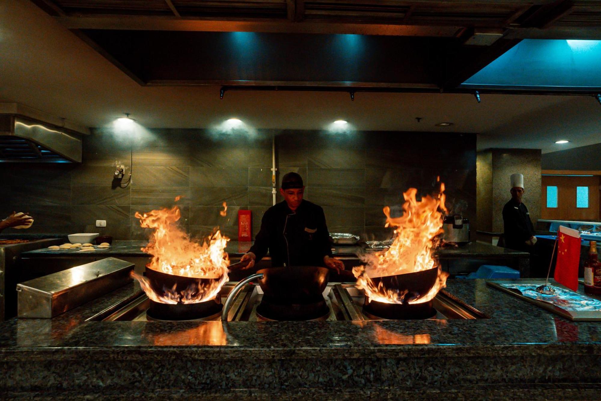 The V Luxury Resort Sahl Hasheesh Hurghada Bagian luar foto A chef cooking with a wok