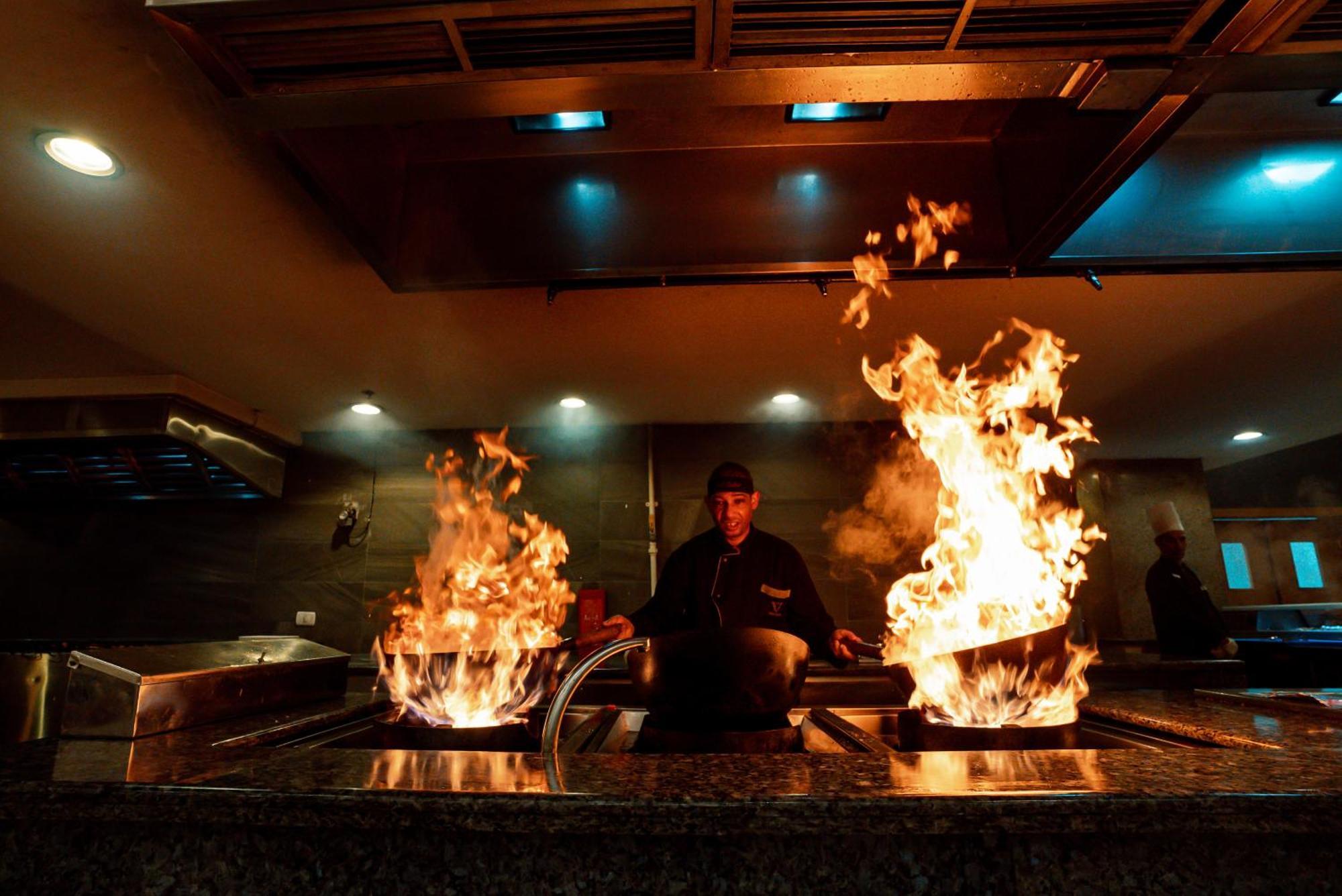 The V Luxury Resort Sahl Hasheesh Hurghada Bagian luar foto A chef cooking with a wok